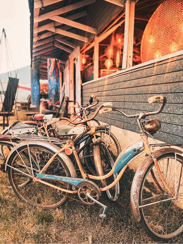 Vintage bicycles parked under a wooden structure with warm lighting.