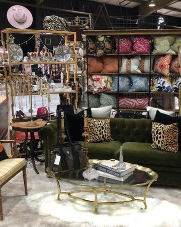Furniture store with various chairs, a couch, and decorative items on shelves.