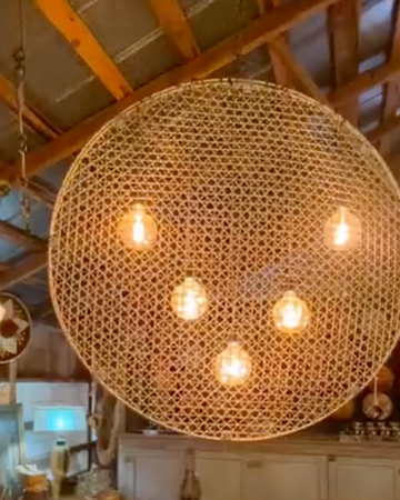 Woven pendant light fixture hanging from a wooden ceiling