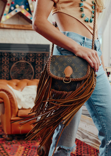 Person holding a fringed handbag by LEather and Vodka with a colorful background